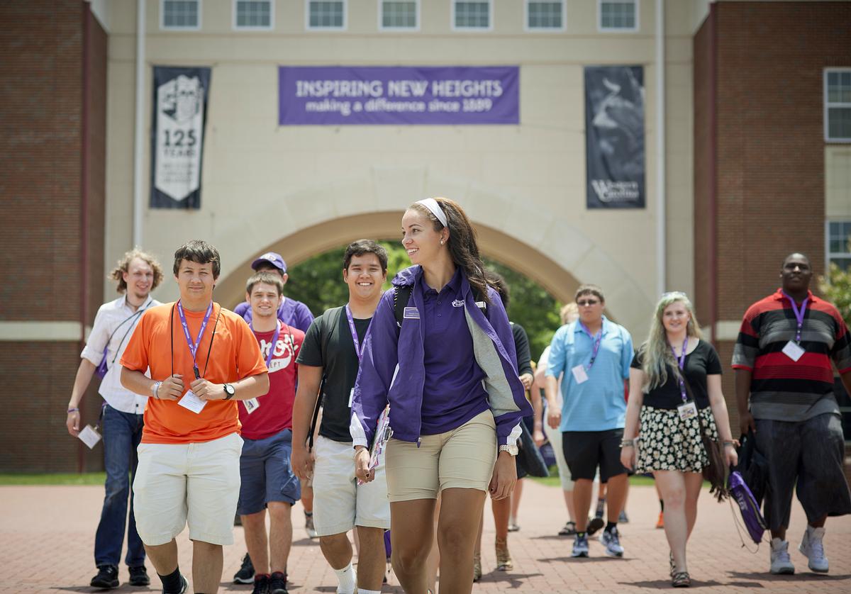 Students and staff walking down a sidewalk