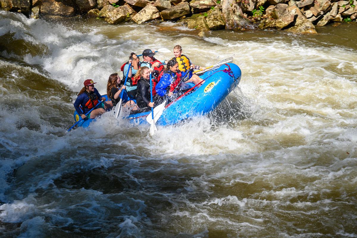 Students and guide rafting over a large current on the Nantahala River