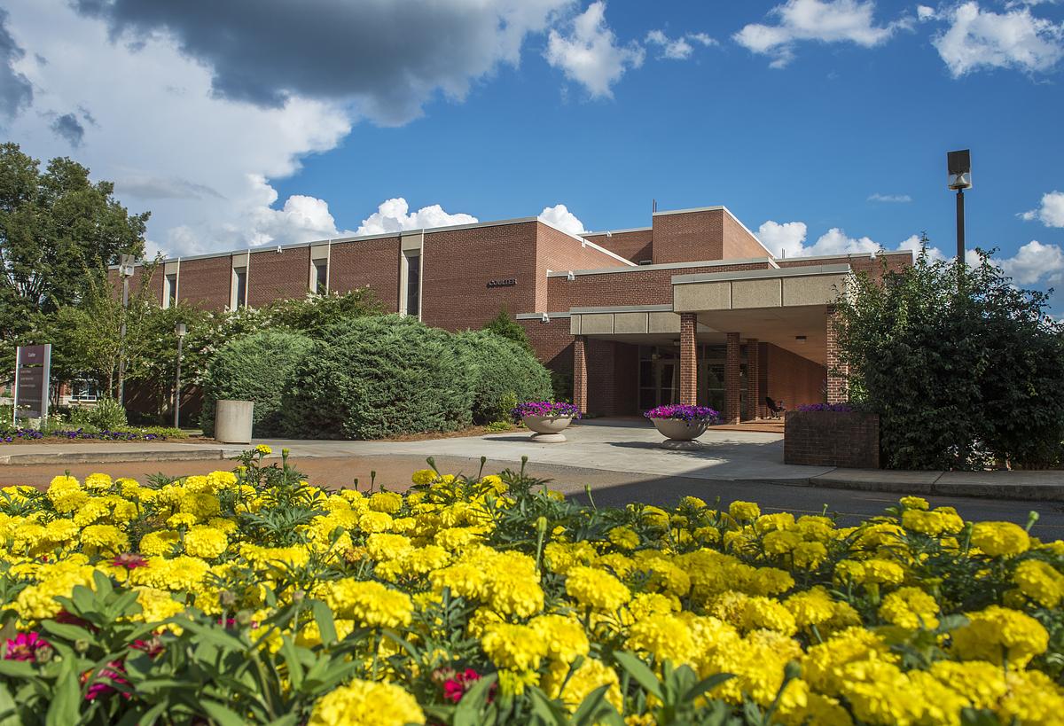 Front entrance of the Coulter Faculty Commons in the summer with flowers