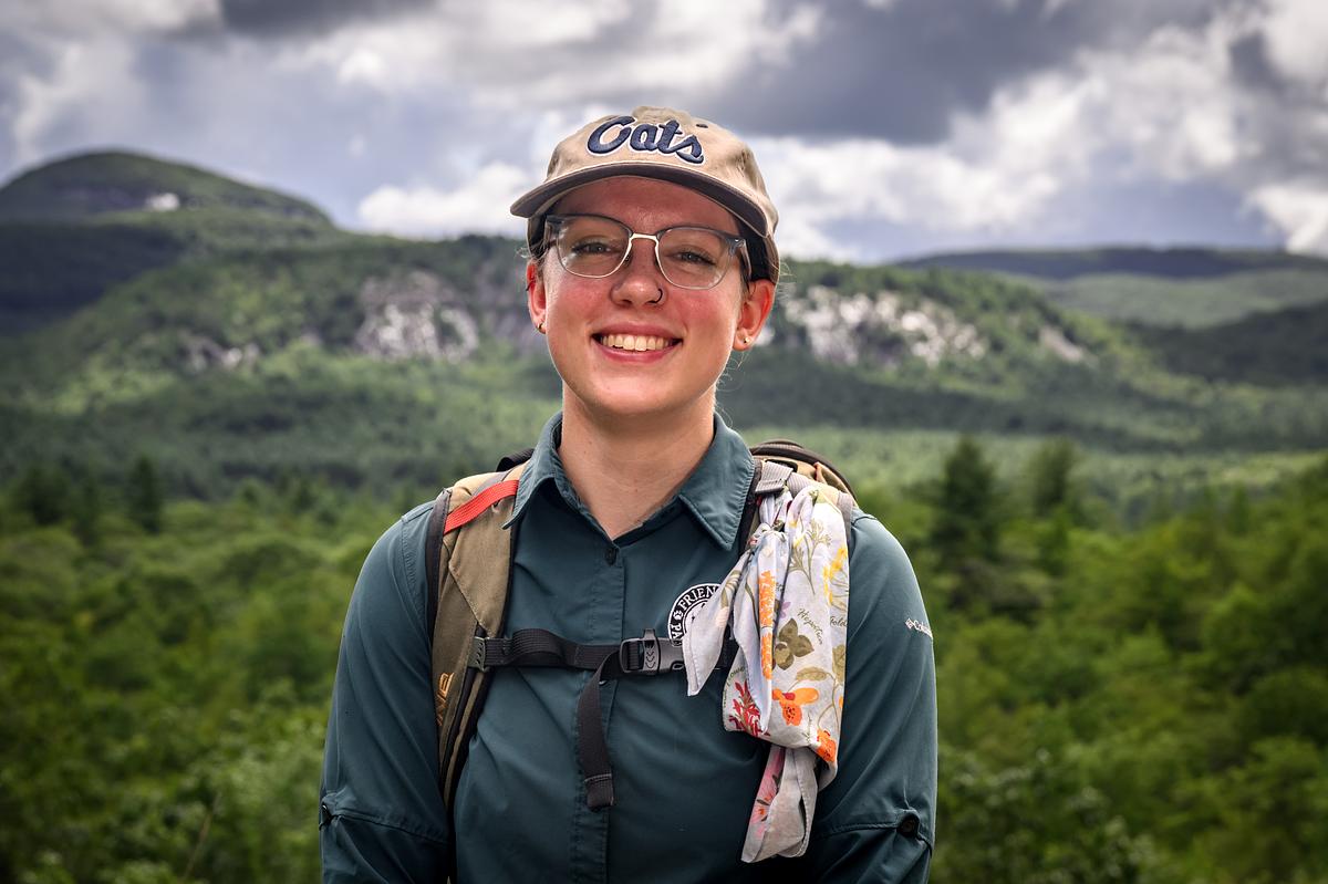Kara McMullen smiling for the camera at a scenic overlook in Panthertown Valley
