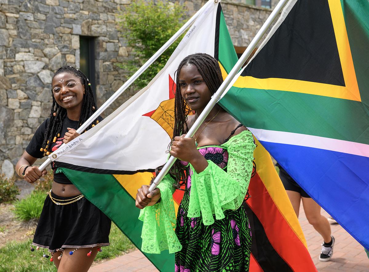 Students walking around campus with flags from various countries for the International Festival