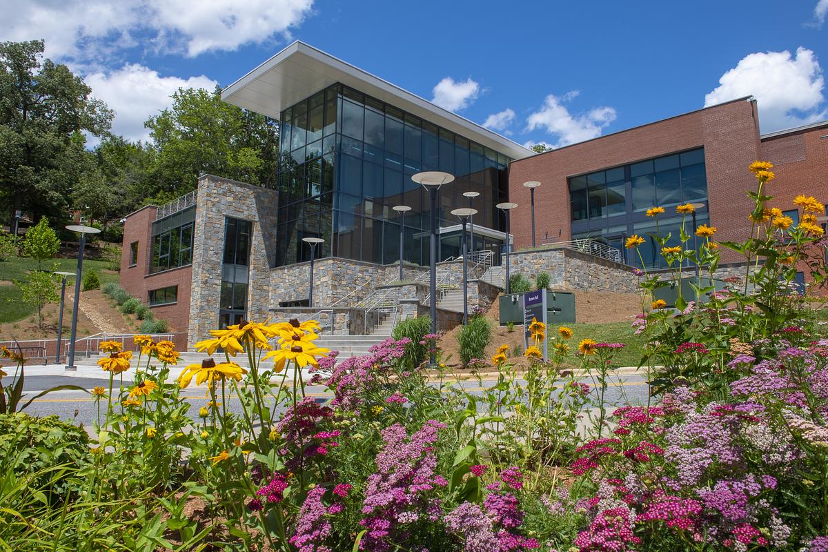 Brown Hall in spring with flowers growing in bounty