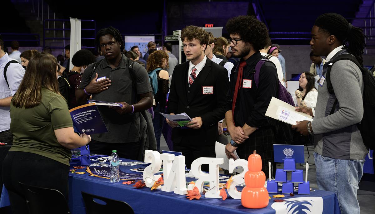 Students talking with a recruiter at a career fair
