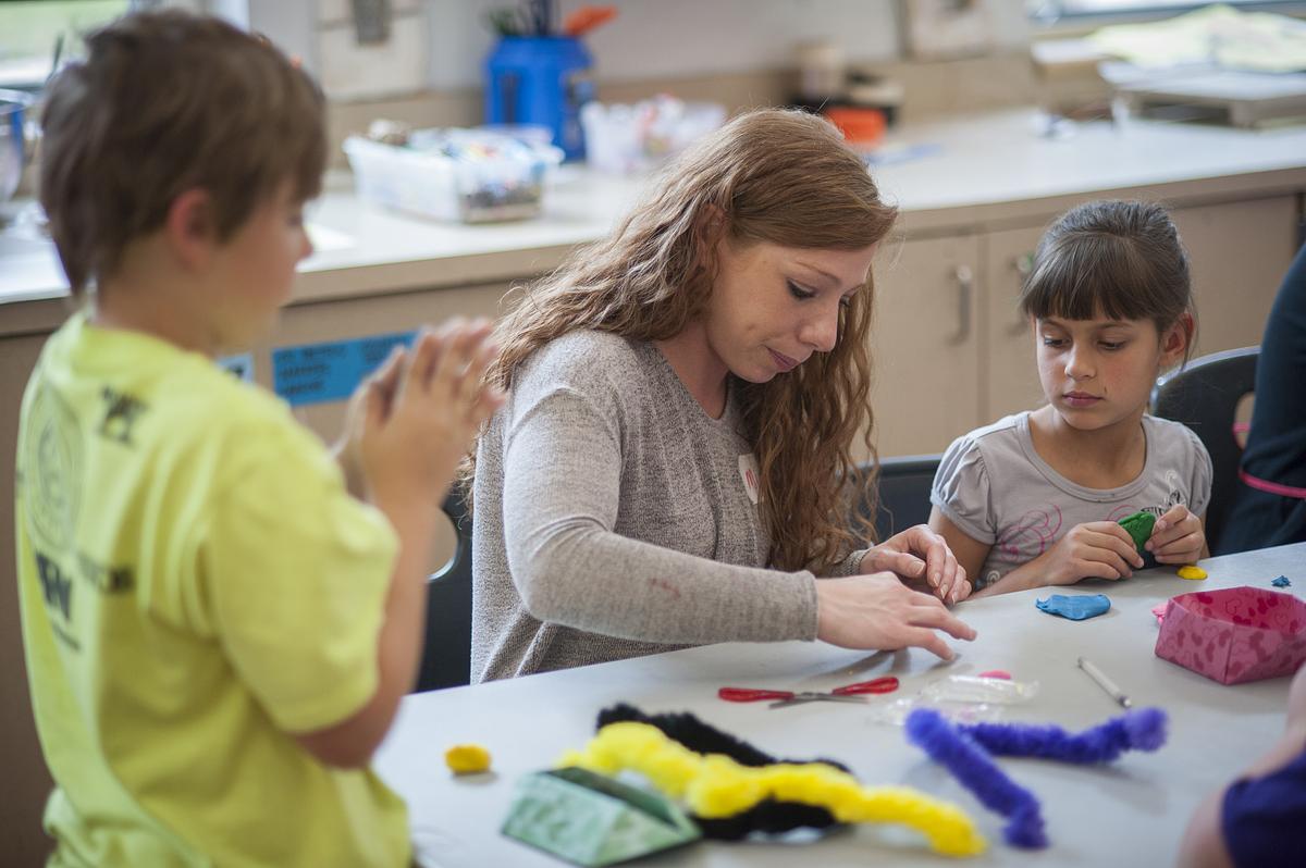 Teacher showing a child how to make a project