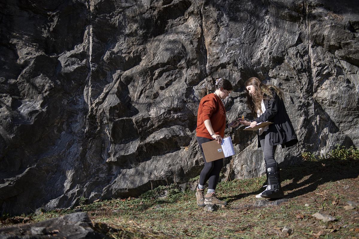 student observing a rock outside