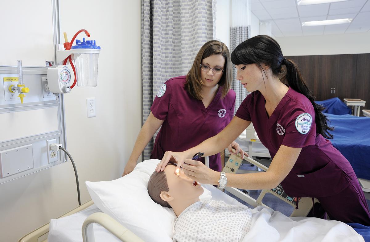 Nursing students practicing and eye examination on a medical mannequin