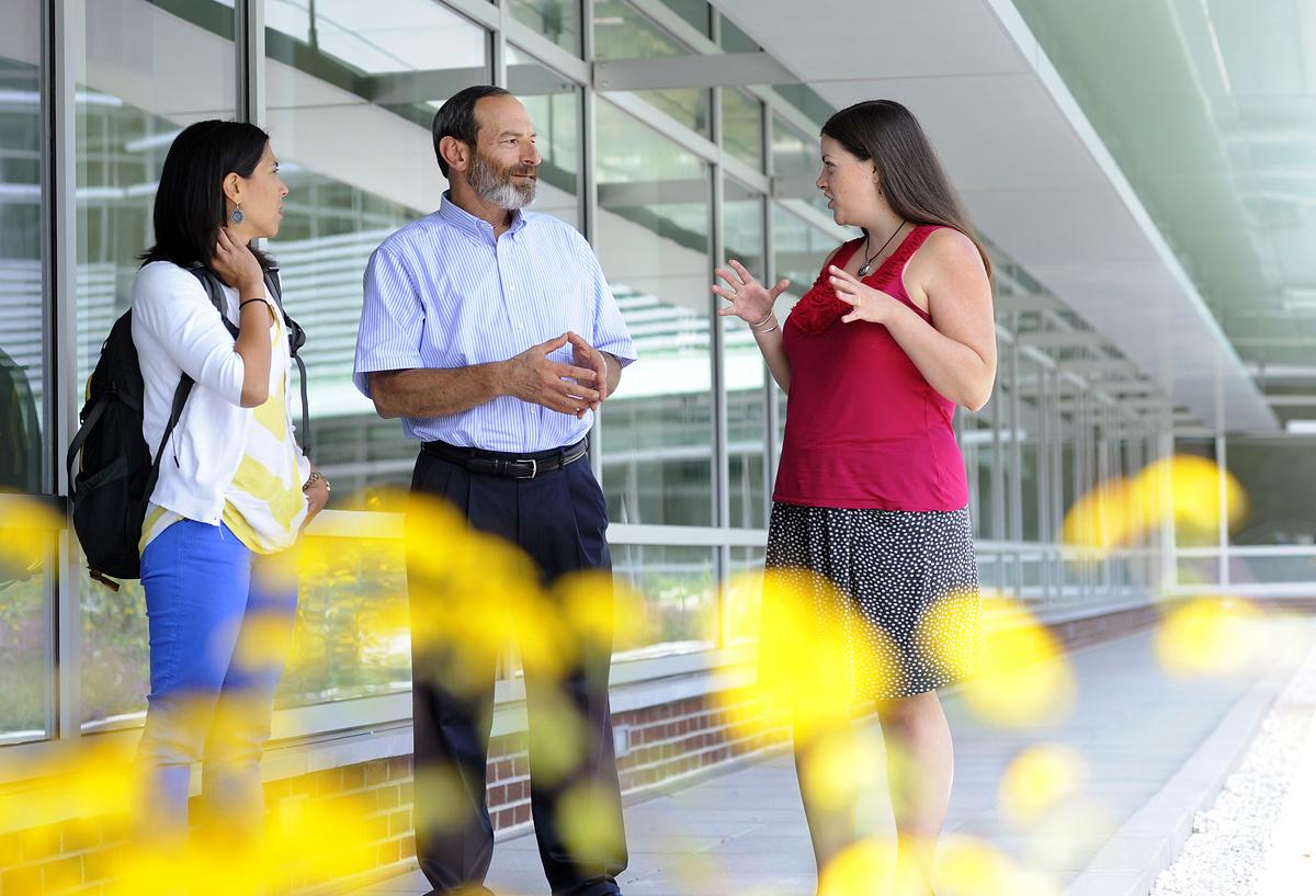 CSD faculty having a discussion outside of the HHS building