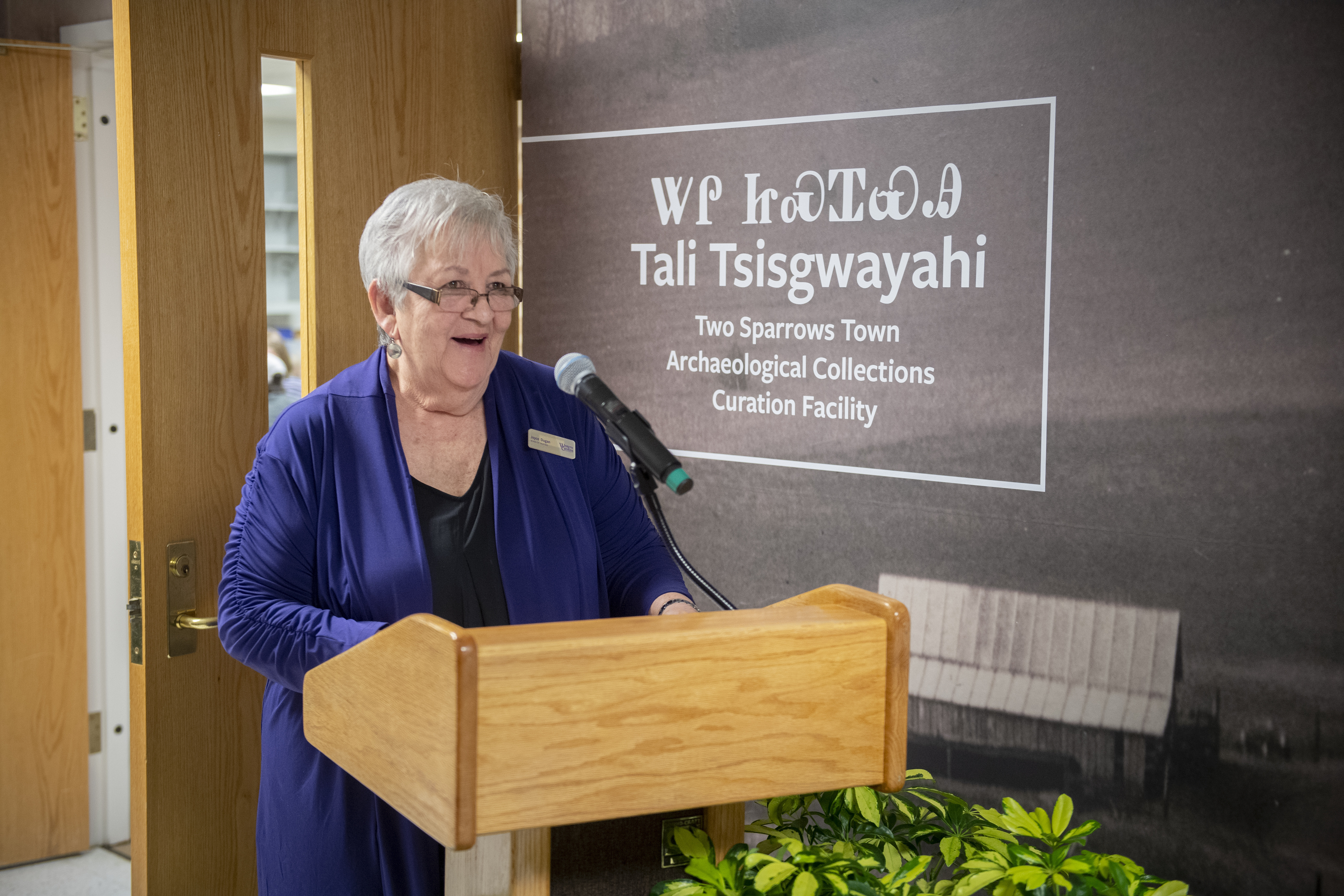 WCU alumna and former EBCI Chief Joyce Dugan stands at a podium speaking to a crowd at WCU