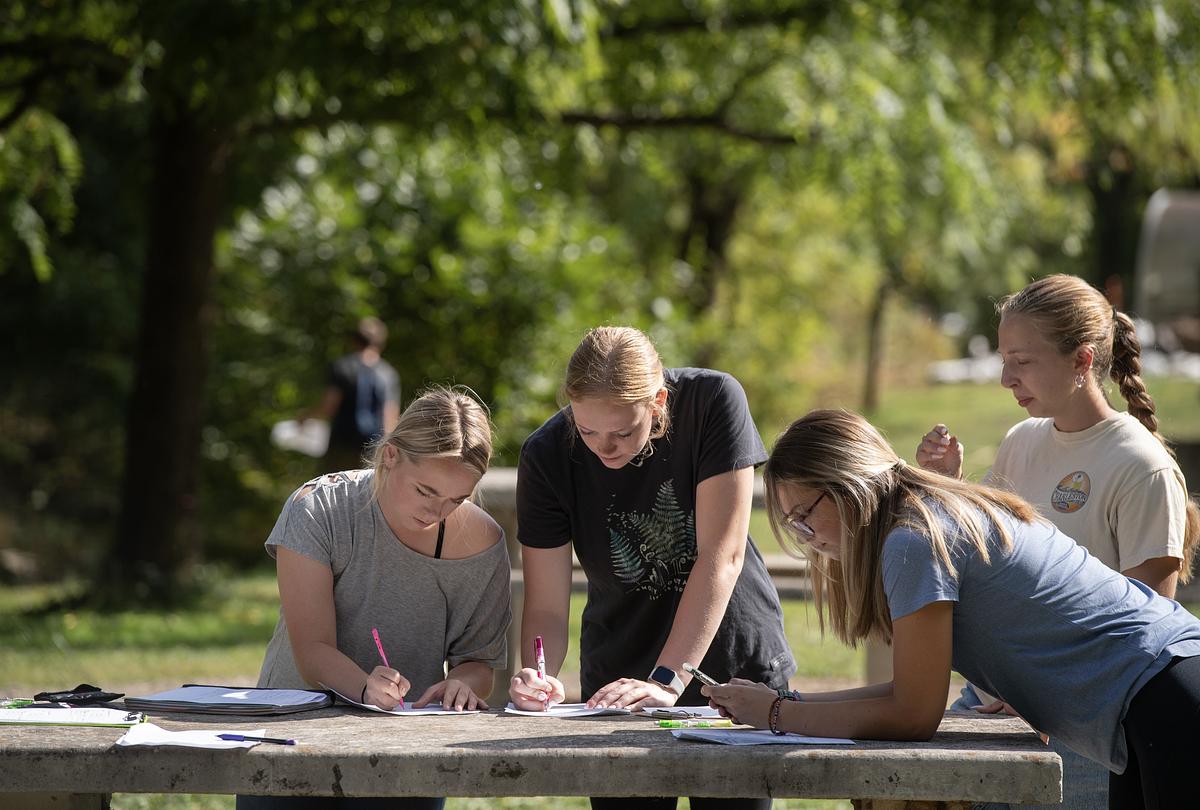 Students working on data sheet in the field