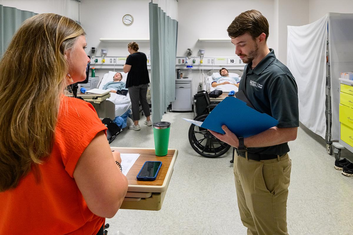 Student nurse holds a folder looking at information for a patient