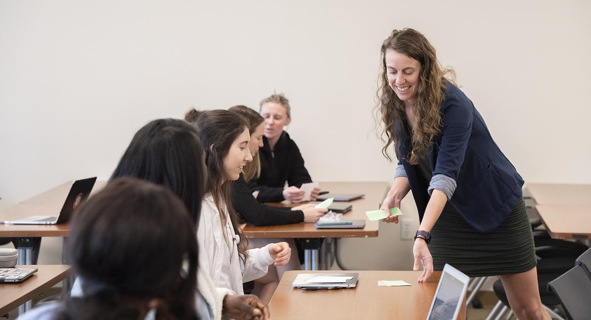 Teacher smiling as they help a student with a project