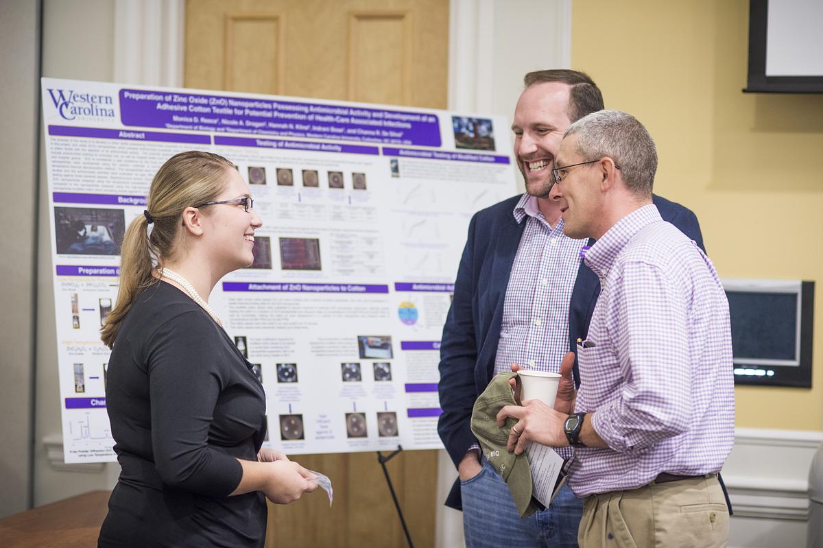 Professors standing in a circle in discussion
