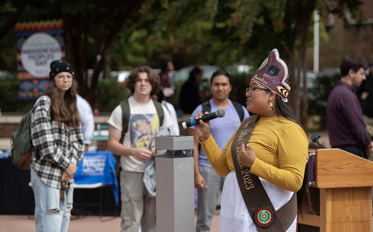 Cherokee speaker presenting in front of a group of on the WCU quad
