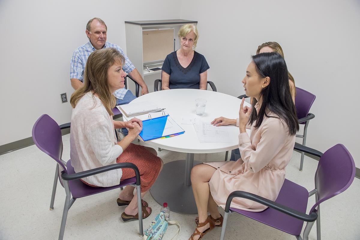 Student and patients sitting around a table for the communications science disorders program