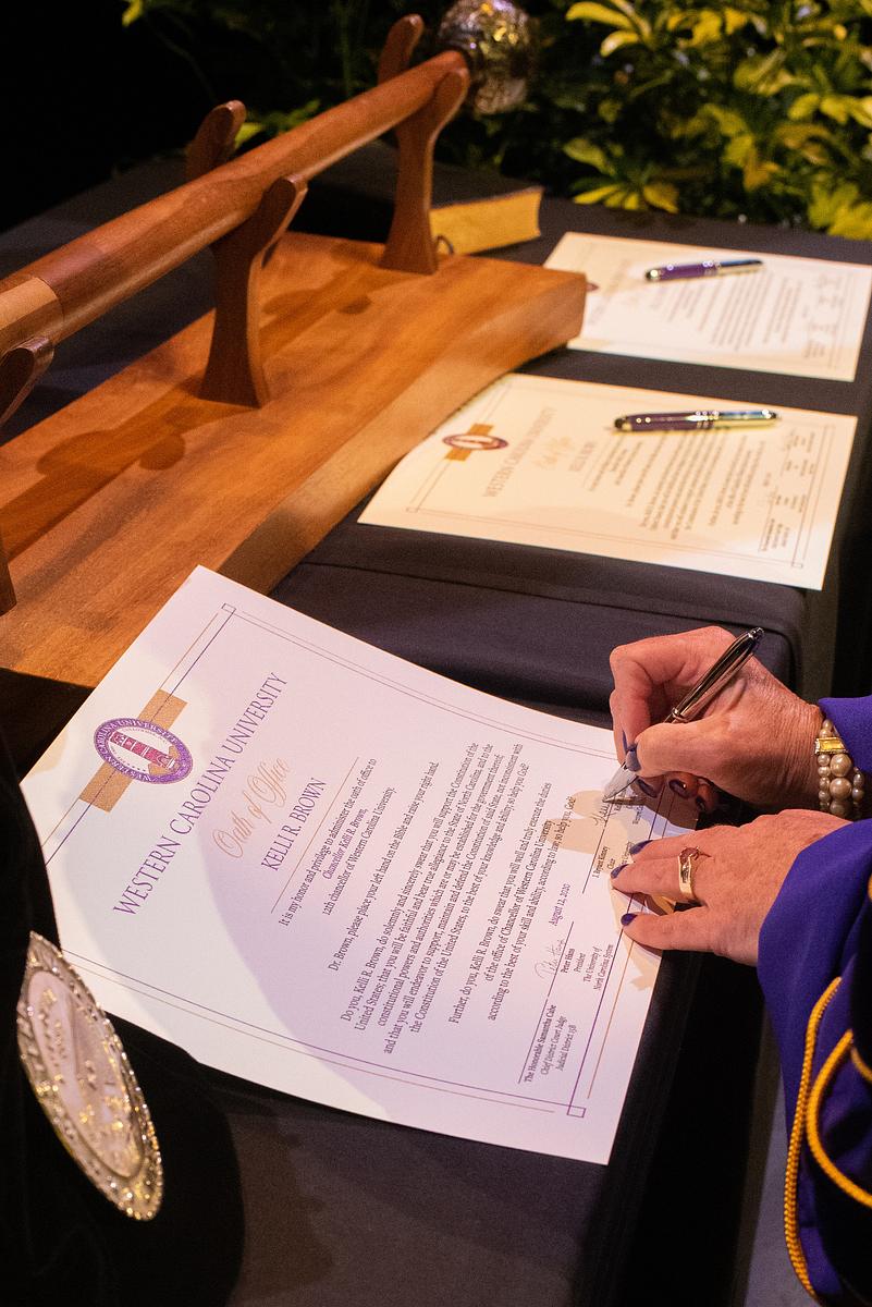 Chancellor Brown signing a document at her desk