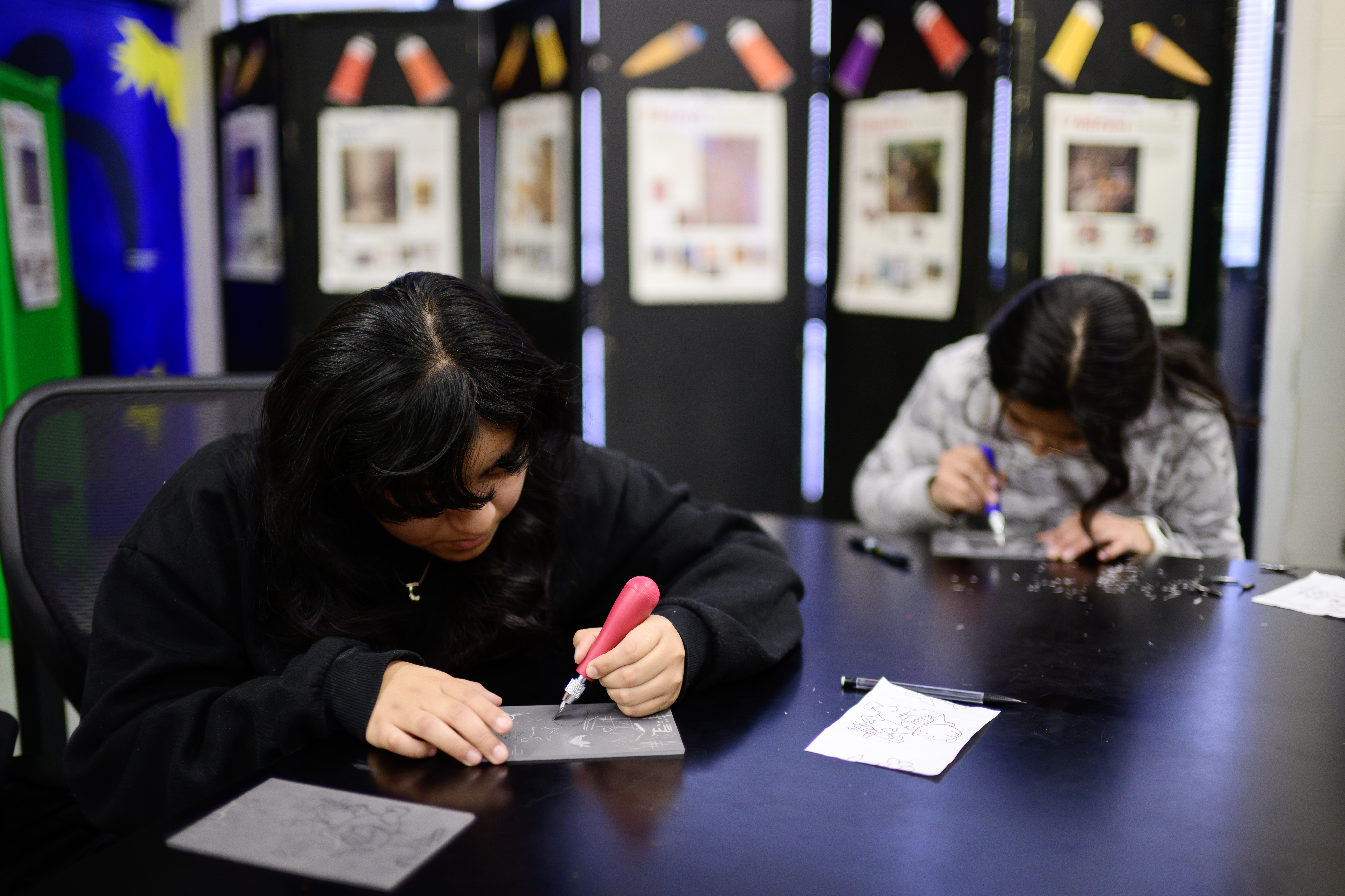 Students working on cutting out designs for the printing press