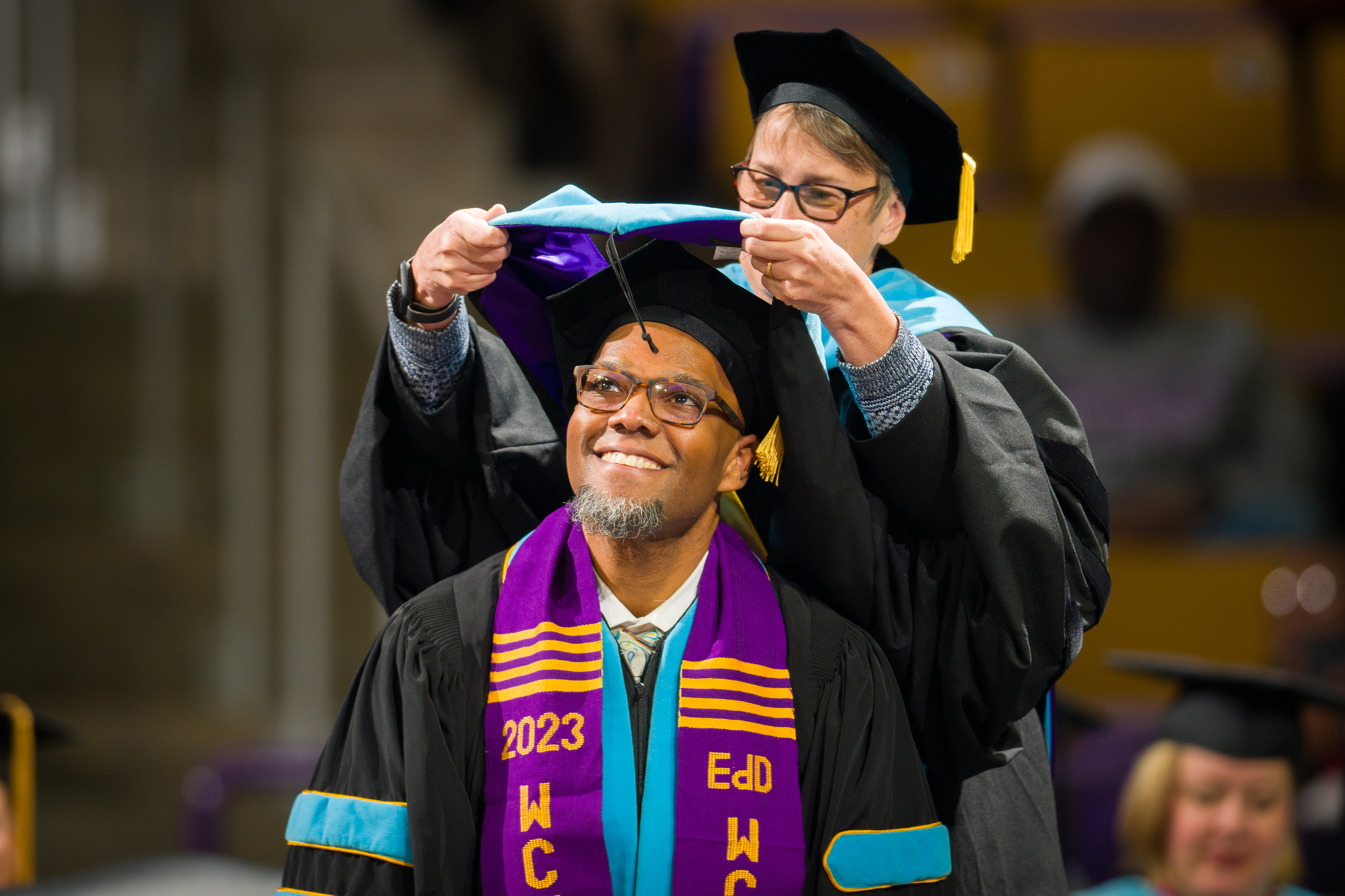 Graduate being hooded by their advisor