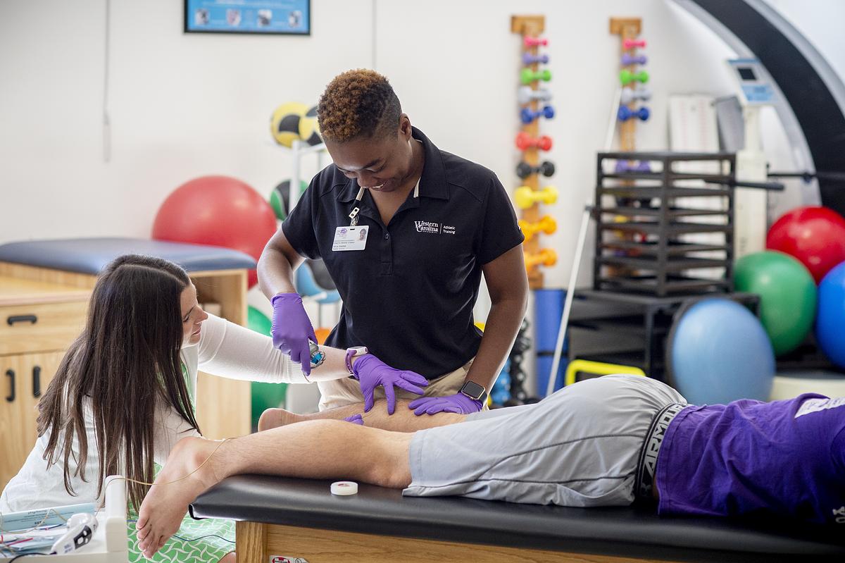ĢƵAthletic Training students inspecting an athletes injury.