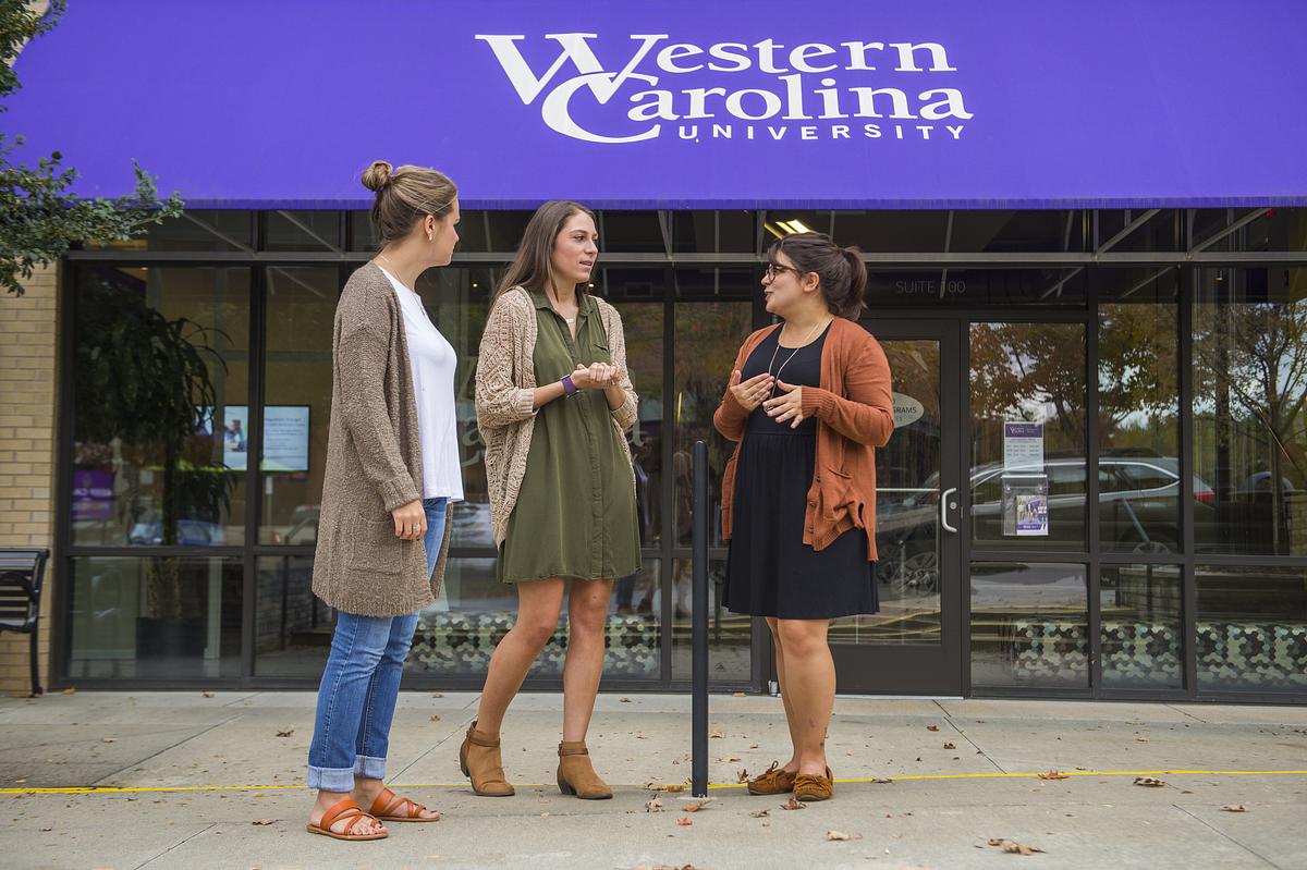 Graduate students standing outside and talking at WCU's Biltmore Park location