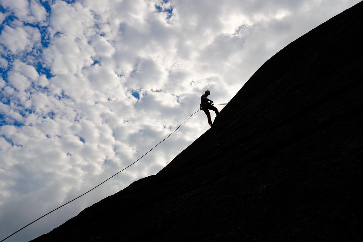 Silhouetted outline of a climber on a rock face