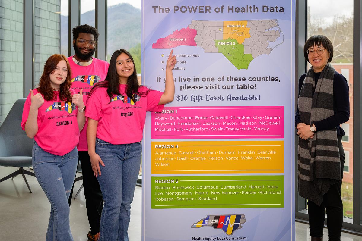 Students and professor stand smiling for a photo during a presentation of Health Data