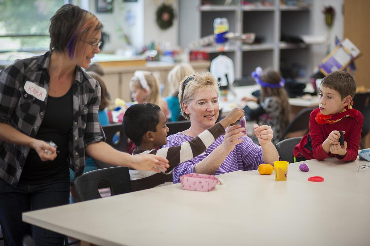 Teachers work with young students on various art projects in class