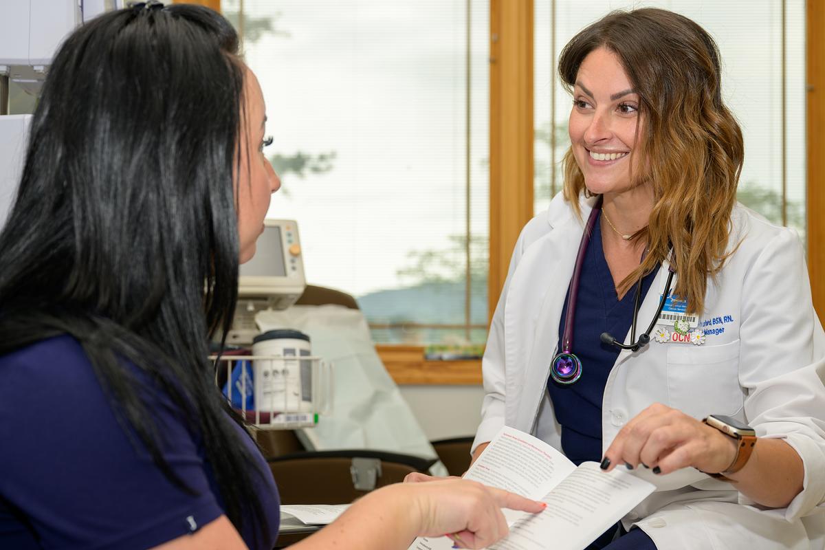 Nursing student working with a patient in a doctors office going over a document together