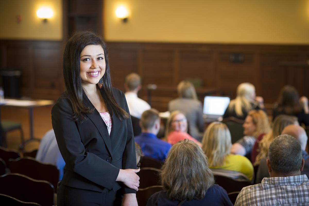 Criminal justice student smiling for the camera in a courtroom
