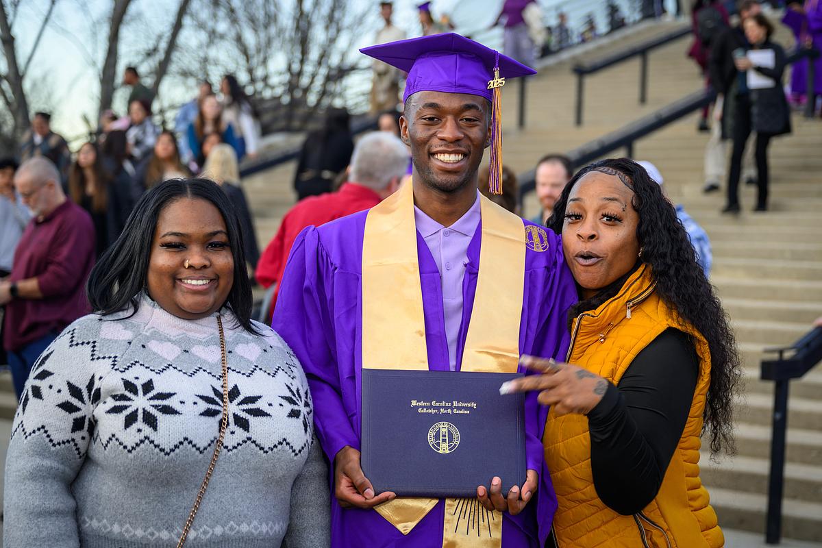 Student with diploma and family