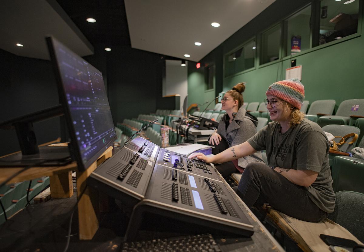 Students working at the sound and light board during a performance