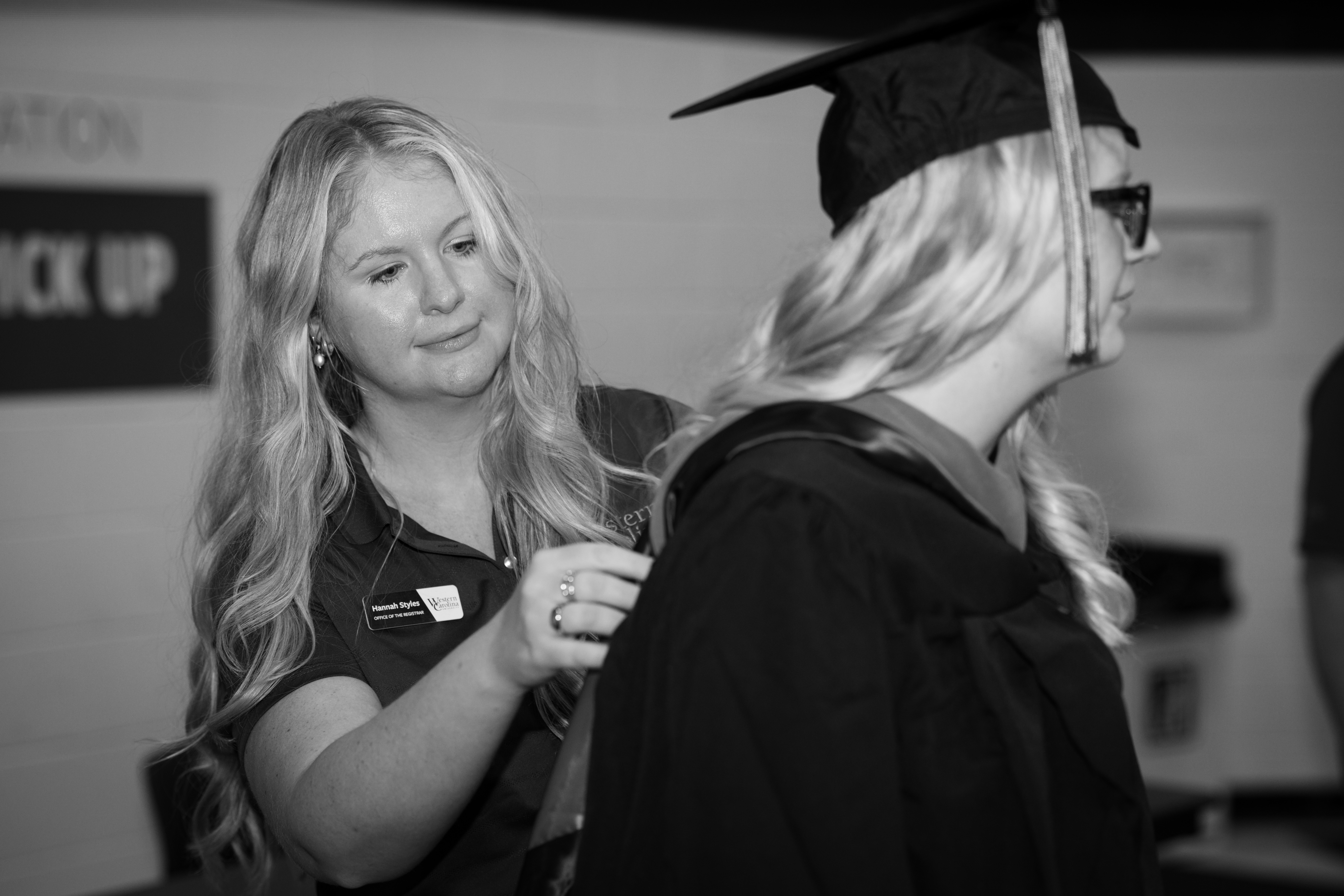 Staff member helping hood a graduate