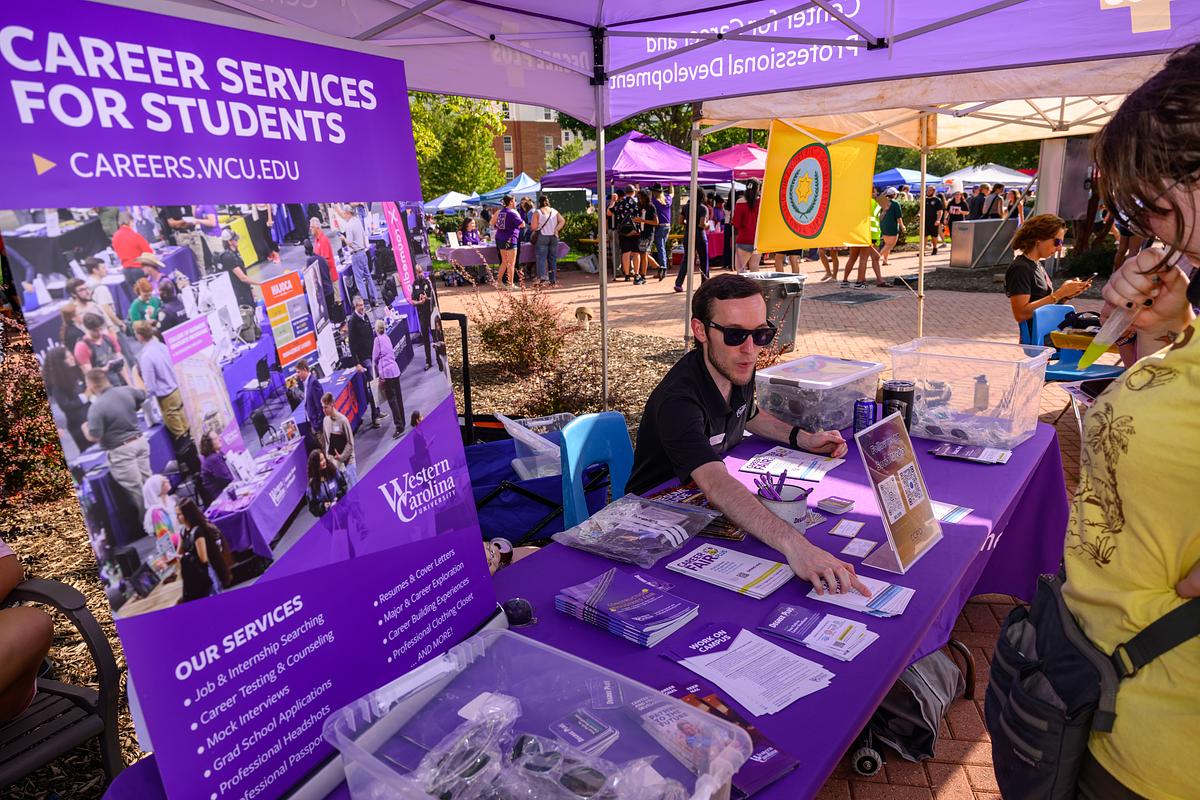 Students get information at an info table on WCU's campus