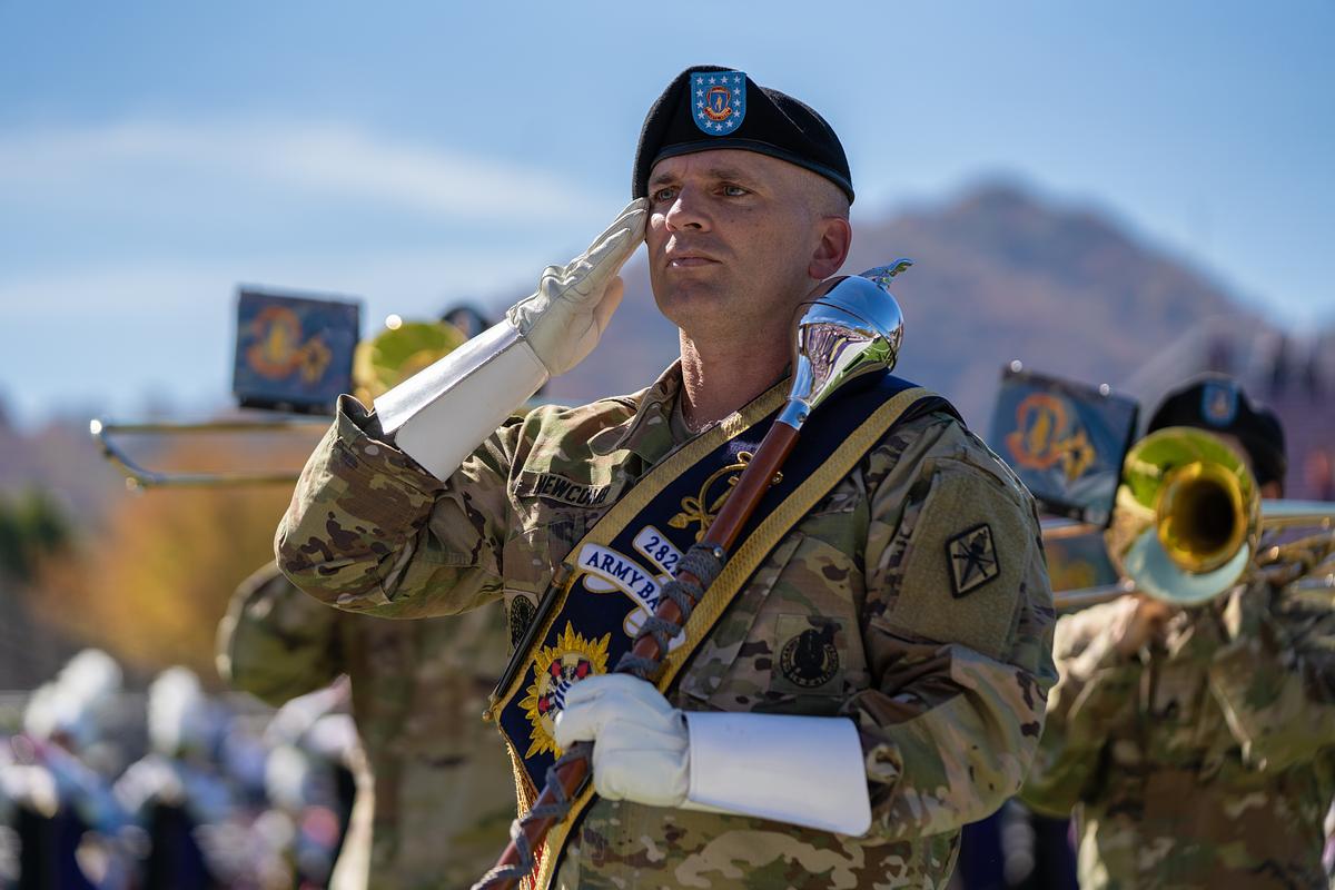 Soldier making salute holding a ceremonial staff