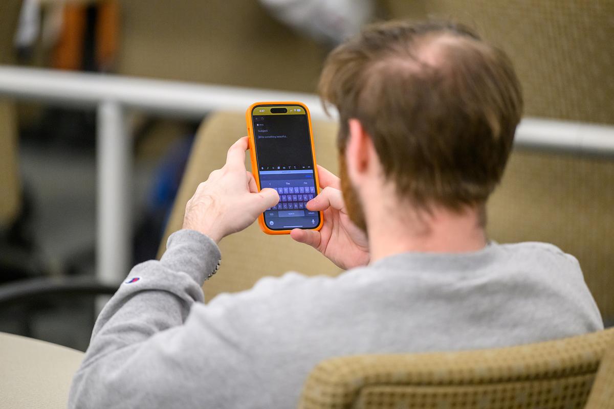 Student holding up their phone while texting