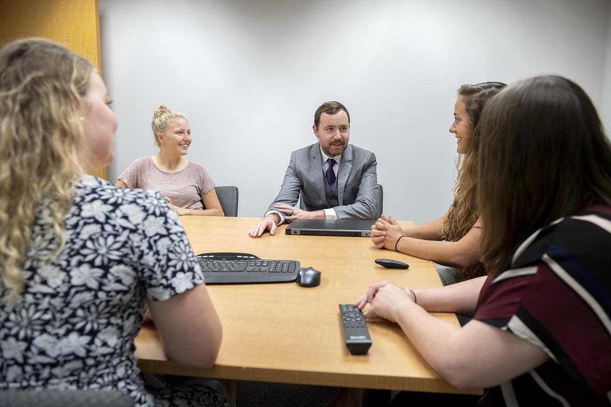 David Solomon sitting around a table in discussion with students during class