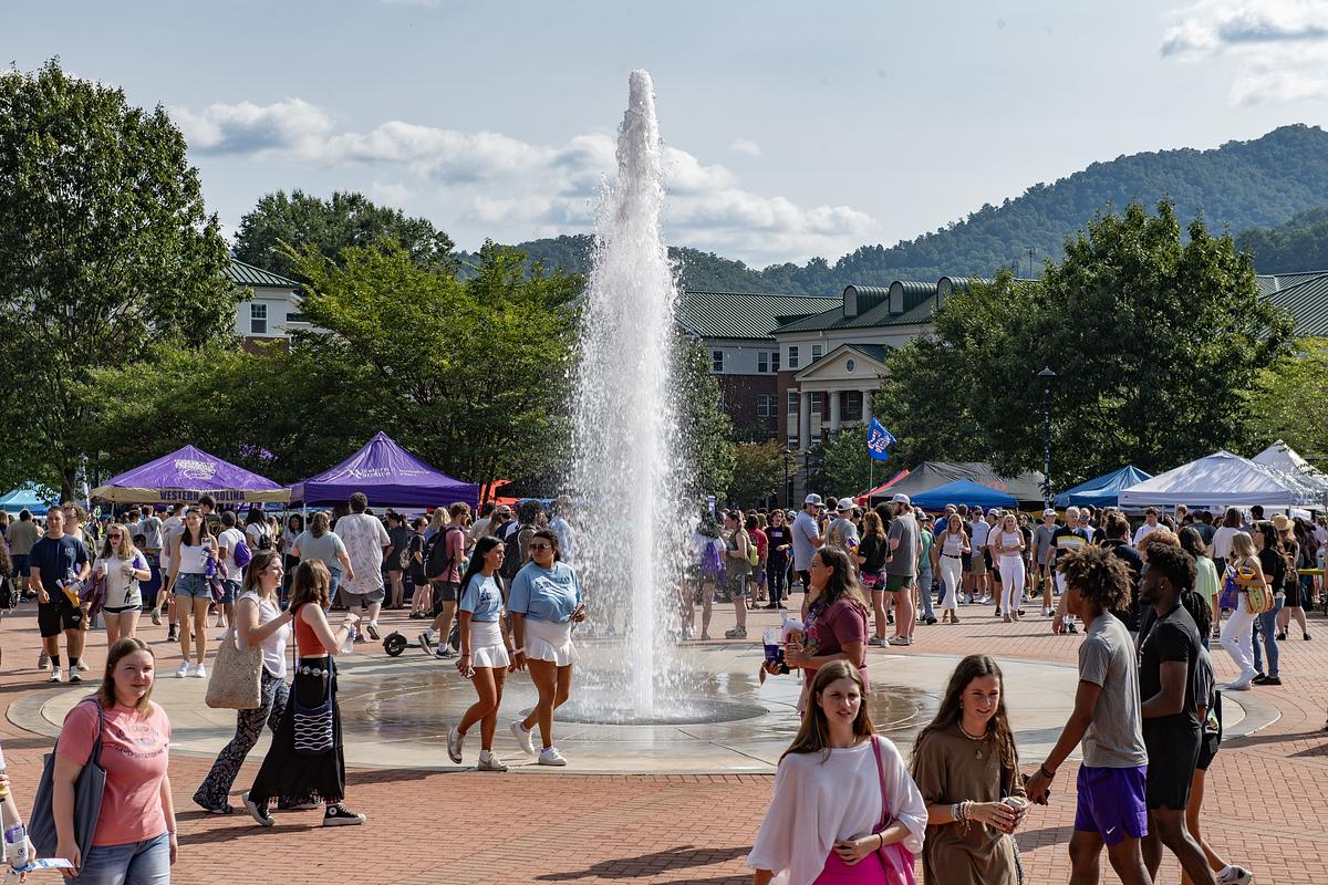 Students walking across campus next to the fountain