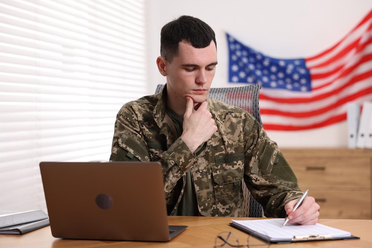 Military student writing at a desk 