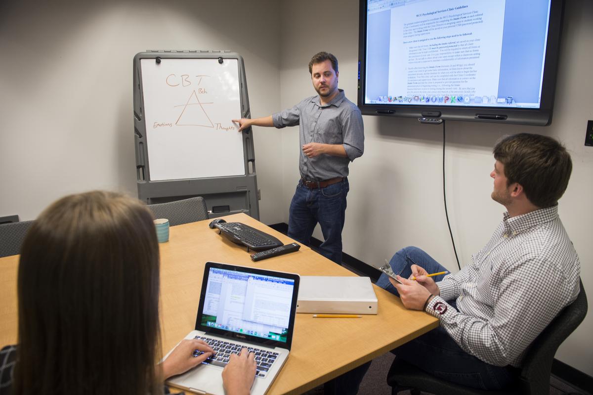 Professor showing students a graph on a board