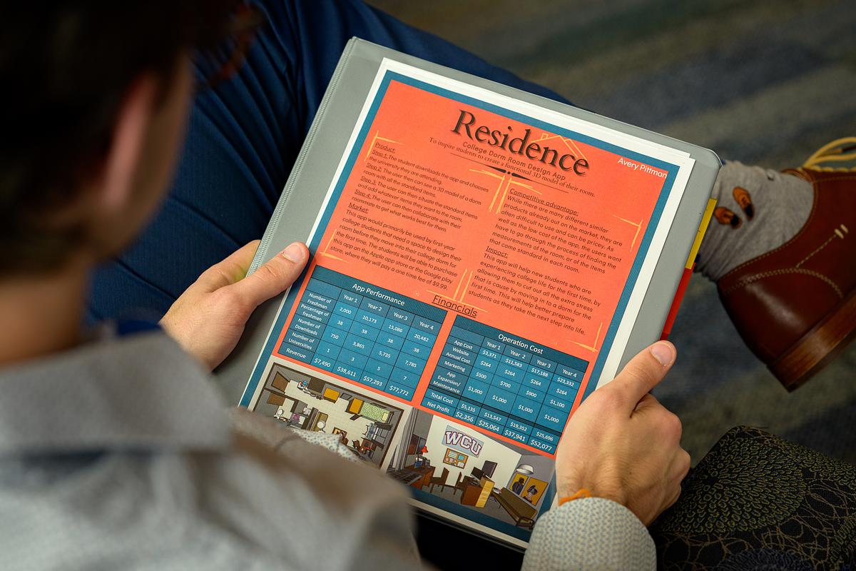 Student holding a document with information about residency at WCU