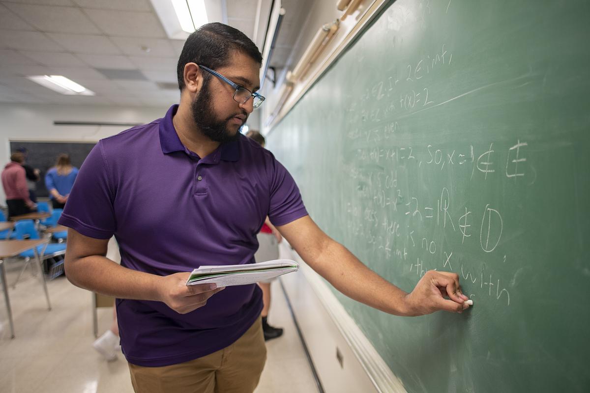 Man solves a math problem on a chalkboard