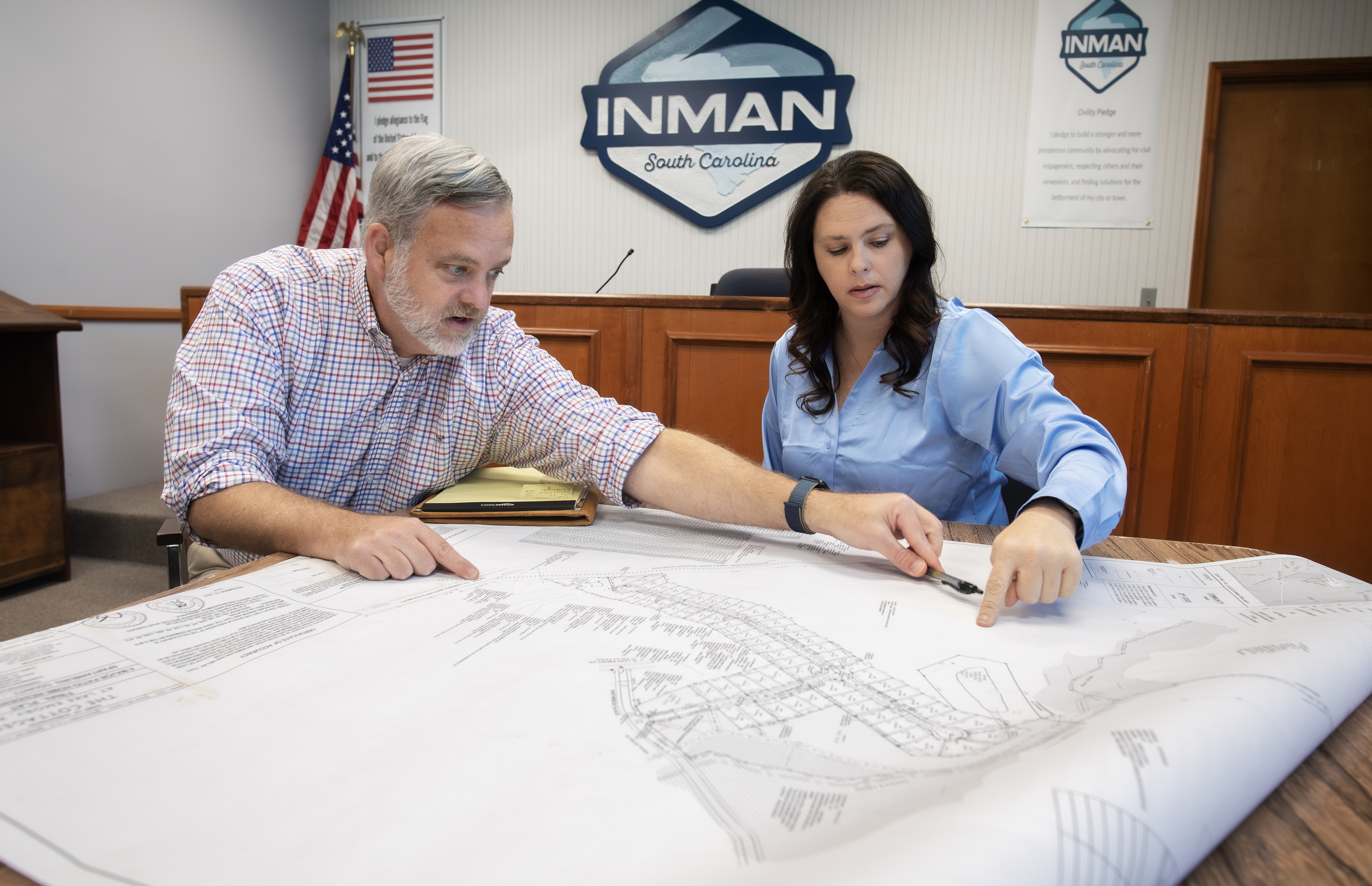 Master of Public Affairs graduate April Williams working someone at a table over blueprints