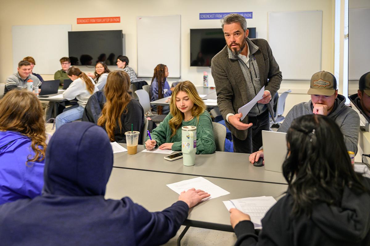 Professor handing out coursework in a political science lecture