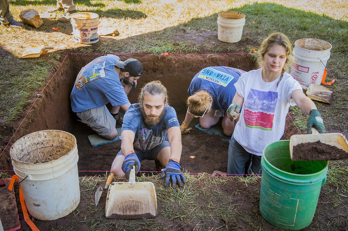 Anthropology Students digging in a hole. 
