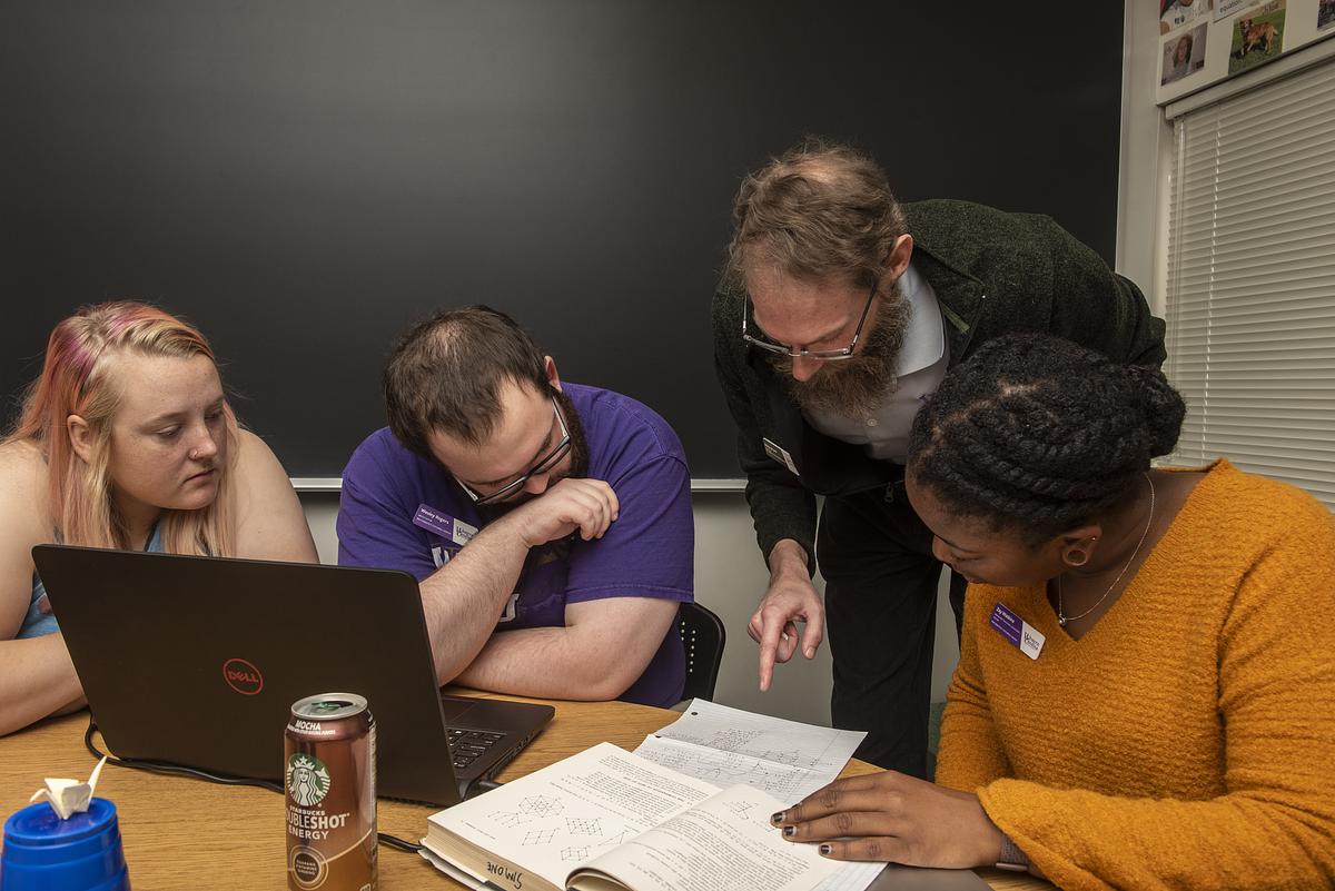 Professor helping students with math problems