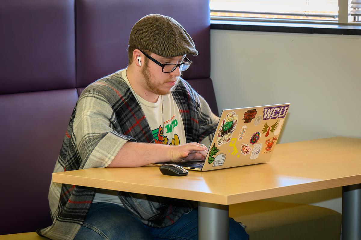 student at laptop (decorative)