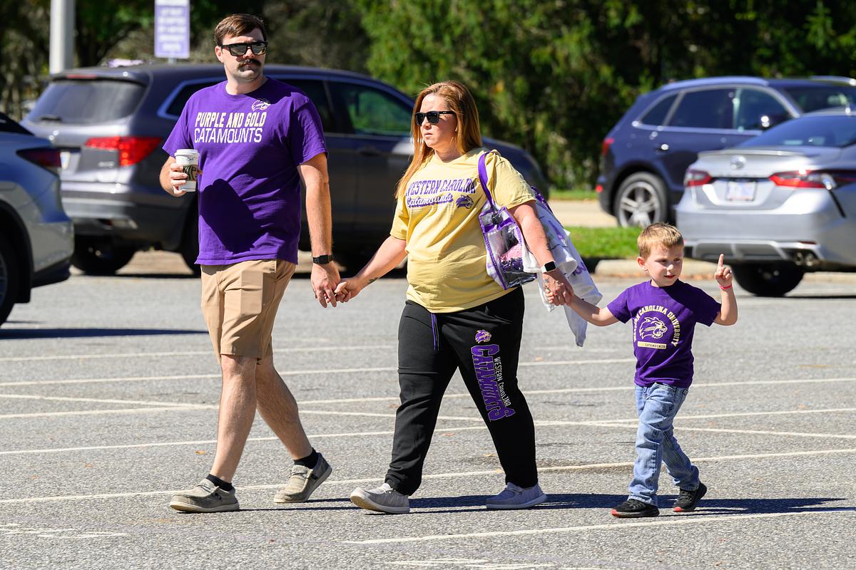 Visitors walking across a parking lot on campus