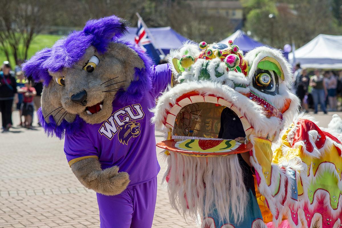 PAWS and a Chinese Dragon Dancer stand next to each other at the International Festival
