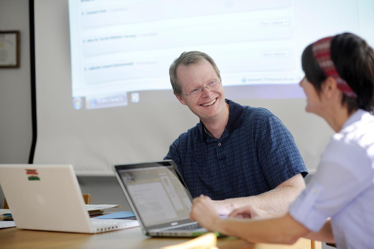 Professor in classroom talking to student