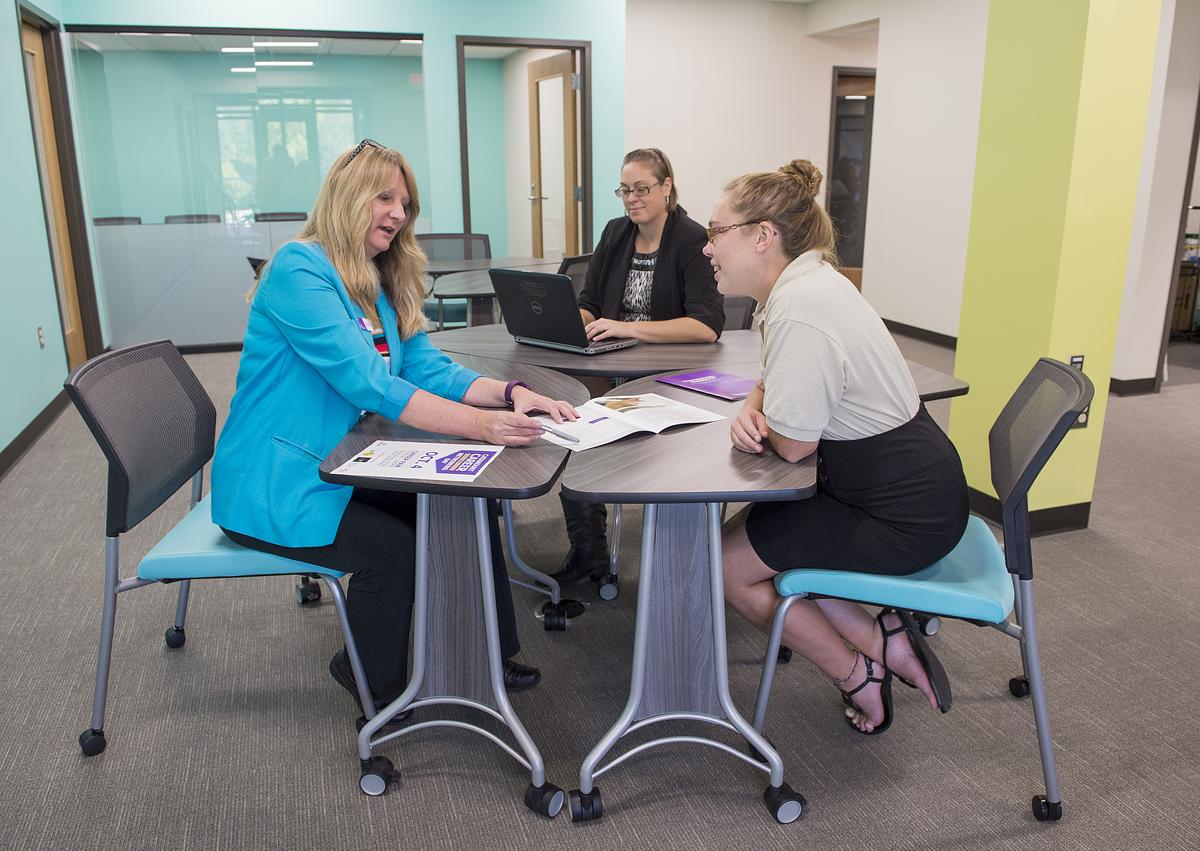 Student and staff working together at a table in the advising center