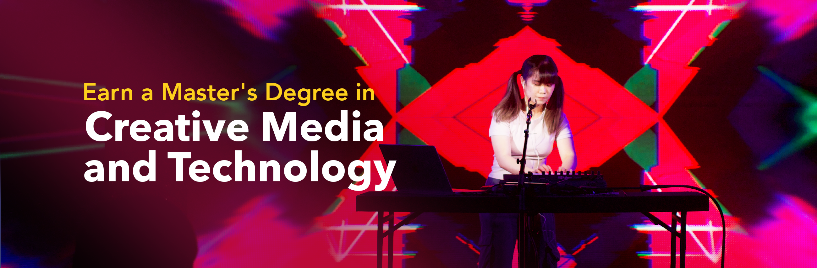 Performer with electronic music setup in front of colorful digital projection